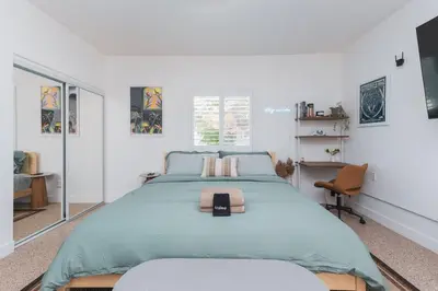 a bedroom with a large bed and a chair at Renovated Stylish Guesthouse By Claremont With Private Patio in Montclair
