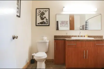 a bathroom with a toilet and a sink and a mirror at 1400 square foot Arts District Warehouse Loft 1 bedroom 1 bathroom in Los Angeles