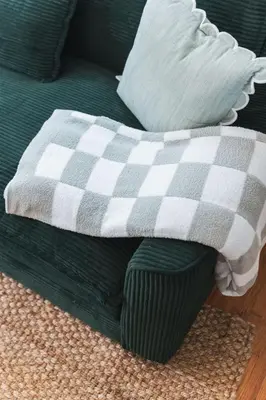 a green couch with a checkered blanket and a pillow at Renovated 1 Bedroom 1 bathroom Cottage Near Larchmont Village in Los Angeles