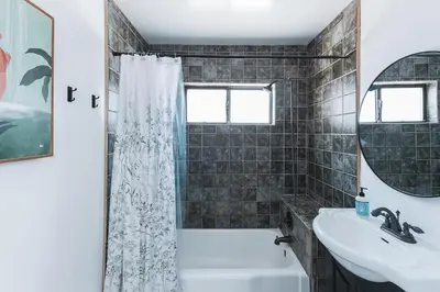 a bathroom with a tub and a sink and a mirror at Charming Vintage 2 bedroom 1 Bathroom Close to Larchmont Village in Los Angeles