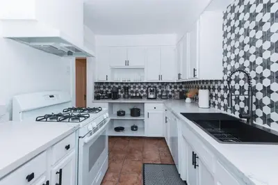 a white kitchen with white cabinets and a stove at Quaint Updated 2 bedroom 1 bathroom Cottage Near Larchmont Village in Los Angeles