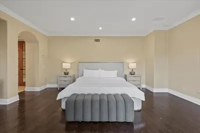 a large bedroom with a white bed and two night stands at 5800 sq ft Gorgeous Tarzana 7 bedroom 9 bathroom home with pool and hot tub in Tarzana