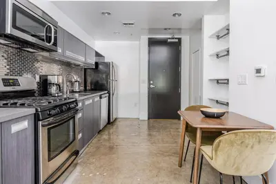 a kitchen with a table and a stove top oven at Blueground Historic Core view nr Grand Park LAX-1424 in Los Angeles