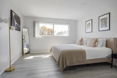 a white bedroom with a large bed and a window at Blueground Melrose pool nr Griffith Park LAX-1399 in Los Angeles