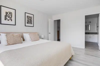 a white bedroom with a large white bed with pillows at Blueground Melrose pool nr Griffith Park LAX-1399 in Los Angeles