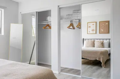 a bedroom with a mirrored closet and a bed at Blueground Melrose pool nr Griffith Park LAX-1399 in Los Angeles