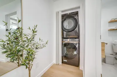 a washer and dryer in a white room with a plant at Work and Play! Apt Less Than 1 Mi to Chino Valley Hospital in Chino