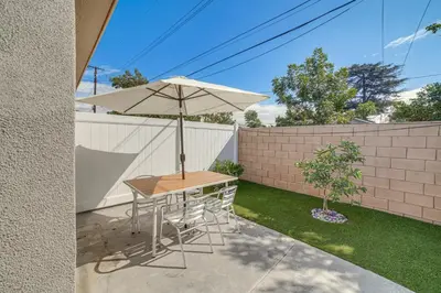 a table with an umbrella next to a fence at Work and Play! Apt Less Than 1 Mi to Chino Valley Hospital in Chino
