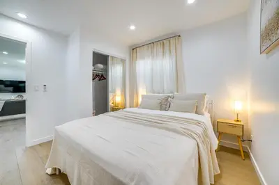 a white bedroom with a large bed with white sheets at Work and Play! Apt Less Than 1 Mi to Chino Valley Hospital in Chino