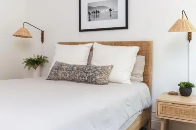 a bedroom with a white bed with a pillow on it at Naples Island Stunning Ocean Cottage By the Beach in Long Beach