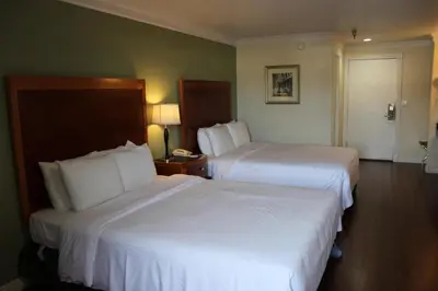 a hotel room with two beds with white sheets at Garvey Inn Hotel - \u5c0f\u53f0\u5317\u9152\u5e97, Monterey Park in Monterey Park