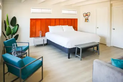 a bedroom with a bed and two chairs and a couch at Beauty And The Beach in Ventura