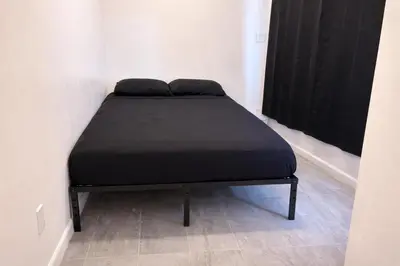 a black bed in a room with a window at La Cienega Soul in Los Angeles