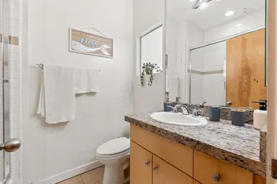 a bathroom with a sink and a toilet and a mirror at Ocean View condo in the heart of Manhattan Beach in Manhattan Beach
