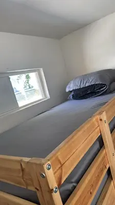 a bed with a wooden frame in a room with a window at The Vibe in Los Angeles