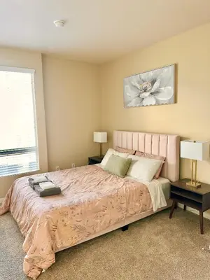 a bedroom with a large pink bed with two lamps at Spacious 2B 2B Pool View Loft Apartment in Marina Del Rey in Los Angeles