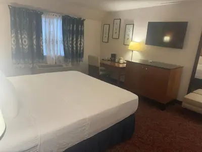 a hotel room with a bed and a television at Hiltop Hotel in Bakersfield