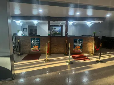 a restaurant lobby with a ticket counter with red carpet at Hiltop Hotel in Bakersfield
