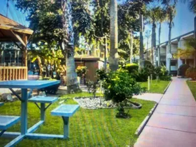 a picnic table and benches in a park at Hiltop Hotel in Bakersfield