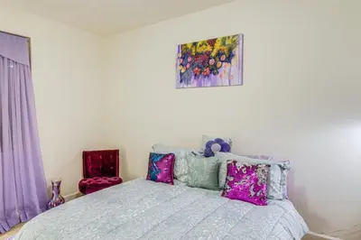 a bedroom with a bed and a painting on the wall at 4 Mi to CSUB Campus Spacious Home with Yard in Bakersfield
