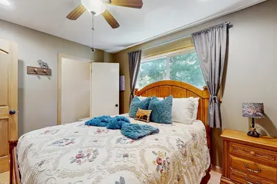 a bedroom with a large bed with blue pillows at Cedar Glen Hideaway in Lake Arrowhead