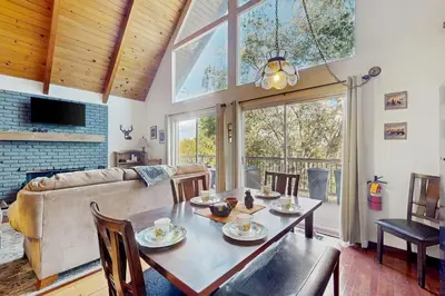 a dining room with a table and a couch at Cedar Glen Hideaway in Lake Arrowhead
