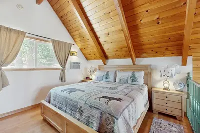 a bedroom with a bed and a wooden ceiling at Cedar Glen Hideaway in Lake Arrowhead