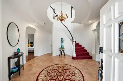 a hallway with a staircase and a chandelier at Mountain View Luxury Estate with Pool in West Hills in Chatsworth Lake Manor