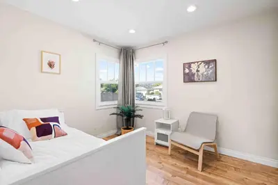 a white bedroom with a bed and a chair at Charming Modern Escape with Outdoor Living in San Dimas