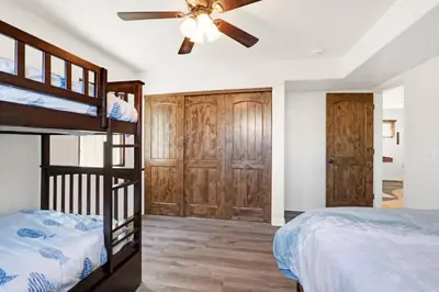 a bedroom with a bunk bed and a ceiling fan at Silverstrand Beach House in Oxnard