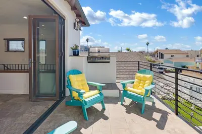 two chairs on the balcony of a house at Silverstrand Beach House in Oxnard