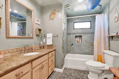 a bathroom with a sink and a toilet and a shower at Silverstrand Beach House in Oxnard