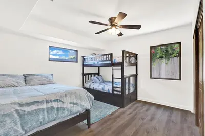 a bedroom with two bunk beds and a ceiling fan at Silverstrand Beach House in Oxnard