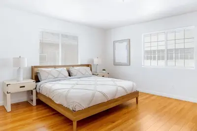 a white bedroom with a bed and a window at Spacious Culver City 4BR - Half Block from Amazon in Los Angeles