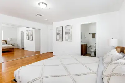 a white bedroom with a large white bed in a room at Spacious Culver City 4BR - Half Block from Amazon in Los Angeles