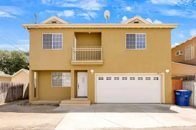 a large yellow house with a white garage at Spacious Culver City 4BR - Half Block from Amazon in Los Angeles