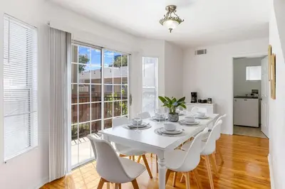 a white dining room with a white table and chairs at Spacious Culver City 4BR - Half Block from Amazon in Los Angeles