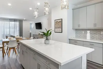a kitchen with white cabinets and a white counter top at Modern Townhouse Near Disneyland & OC Beaches in Covina