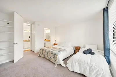 a white bedroom with two beds and a window at Lux Marina Village with parking in Los Angeles