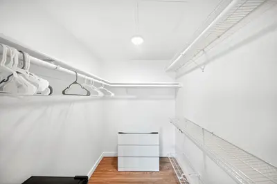 a walk in closet with white walls and wooden floors at fusion hollywood in Los Angeles