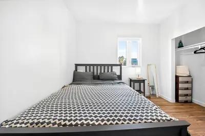 a bedroom with a large bed in a white room at fusion hollywood in Los Angeles