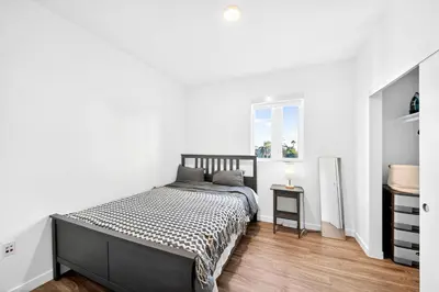a white bedroom with a bed and a table at fusion hollywood in Los Angeles
