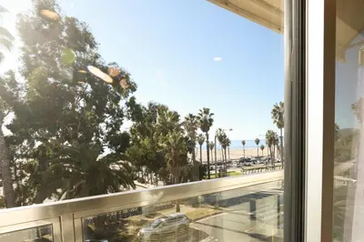 a window with a view of a beach and palm trees at SM ocean view in Los Angeles