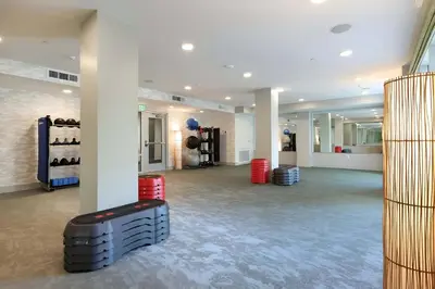 a large room with white walls and a gym with red drums at Charming 2BR Retreat Pool Gym 10min to Disneyland in Santa Ana