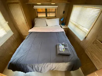 a bed in a small room in a tiny house at Affordable Rooms in RV Trailer in Los Angeles
