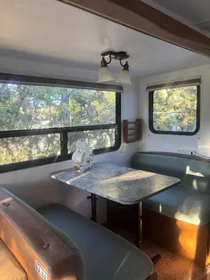 a table in the back of a train with windows at Comfortable Guest RV With EV charger Semi Rural Area in Bodfish