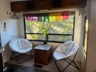 two chairs and a window in an rv at Comfortable Guest RV With EV charger Semi Rural Area in Bodfish