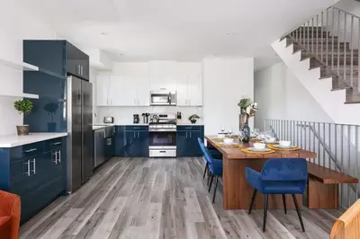 a kitchen with blue cabinets and a wooden table at Prestige 5BR Townhome Near LA Hot Spots in Los Angeles