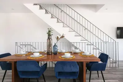 a dining room with a wooden table and blue chairs at Prestige 5BR Townhome Near LA Hot Spots in Los Angeles