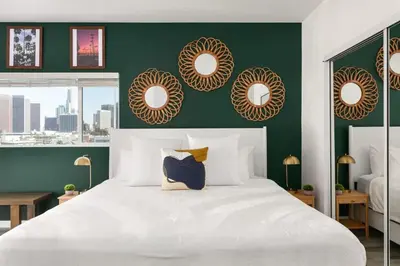 a bedroom with a large white bed with a green wall at Prestige 5BR Townhome Near LA Hot Spots in Los Angeles